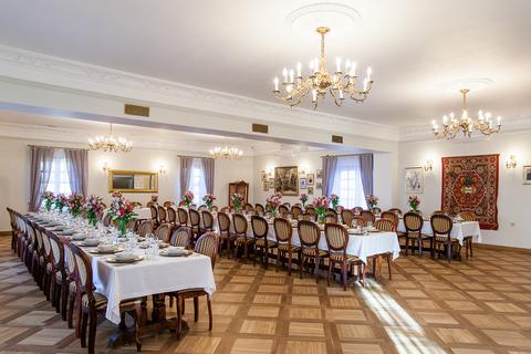 Sala z kilimem i długimi stołami